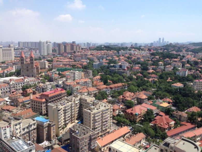 Figure 3. Old section of Qingdao City encroached by new developments. Qingdao has experienced erosion of its historical identity by recent urban developments. The city is famous for its unique combination of German and Chinese architecture and is famous for Tsingdao Beer. (Photos taken by Zhili Yang on 07/04/2015)